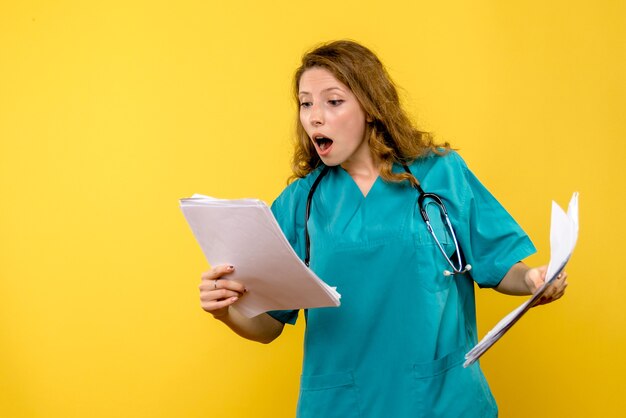 Front view female doctor with files on the yellow space