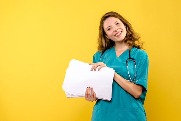 Front view female doctor with files on yellow space