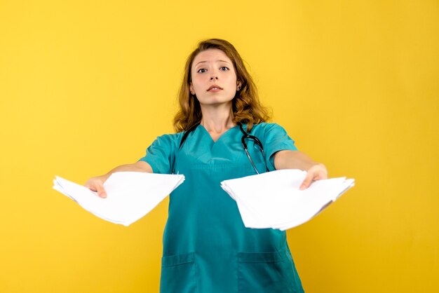 Front view female doctor with files on yellow space