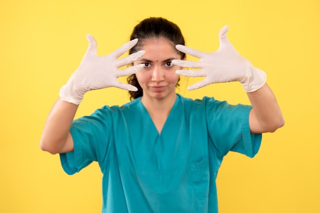 Free photo front view female doctor with latex gloves showing her hands