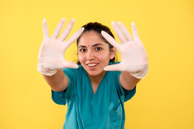 Front view female doctor with latex gloves showing her hands