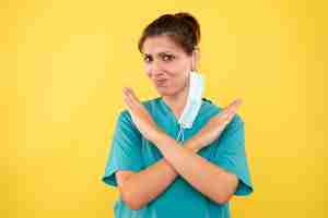 Free photo front view female doctor with mask on a yellow background