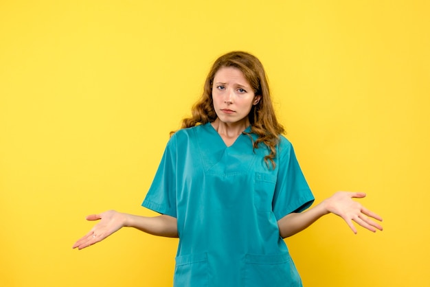 黄色い空間に悲しそうな顔を持つ女性医師の正面図