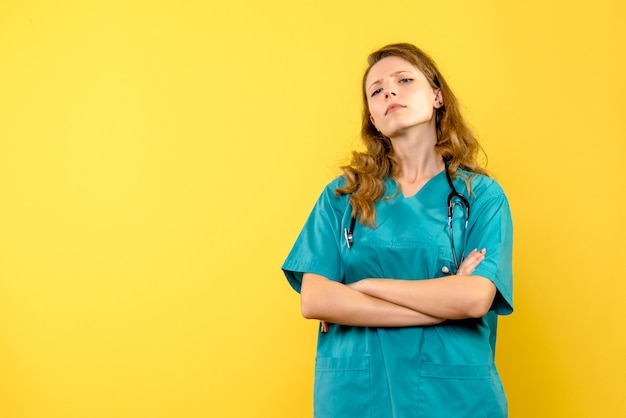 Front view female doctor with serious face on yellow space