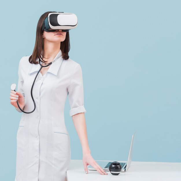 Front view of female doctor with virtual reality headset and stethoscope