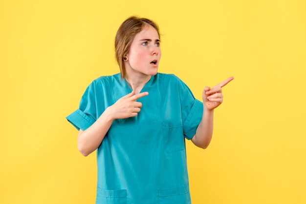 黄色の背景の感情病院の薬の健康の正面図の女性医師