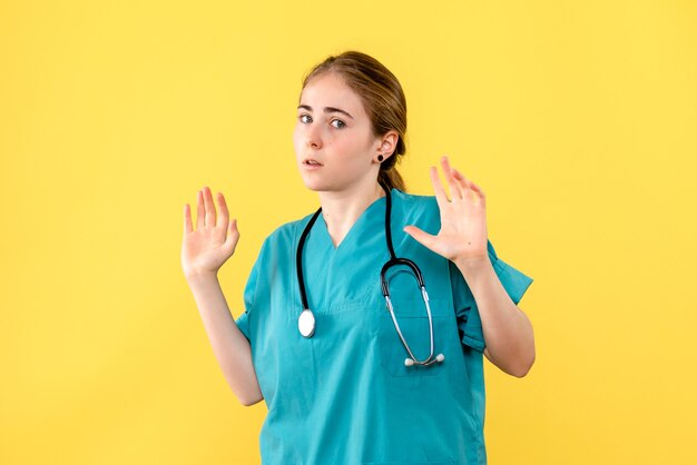 Вид спереди женщина-врач на желтом фоне эмоции больница здоровье медик