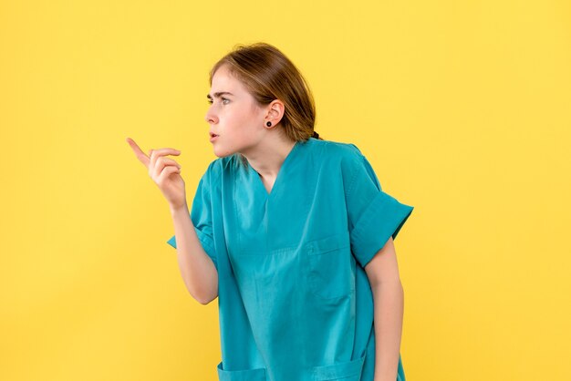 Вид спереди женщина-врач на желтом фоне здоровье эмоции больница медик