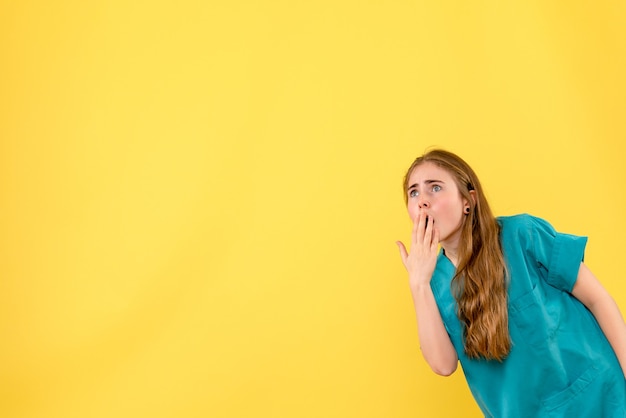 Front view female doctor on yellow background health medic emotion hospital