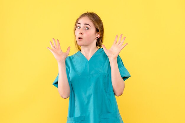 Front view female doctor on yellow background medic emotion virus hospital health