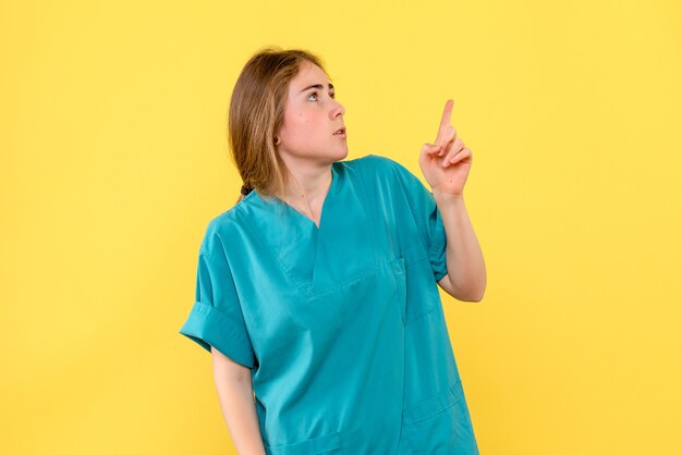 Front view female doctor on yellow background medic emotions hospital health virus