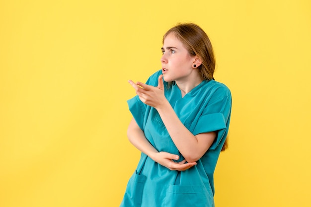 Front view female doctor on yellow background medic emotions hospital health virus