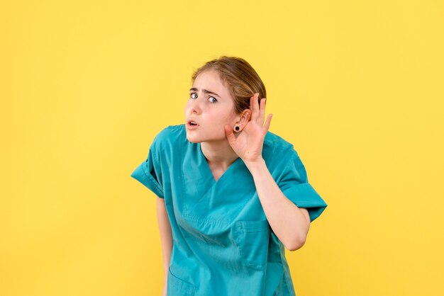 Front view female doctor on a yellow background medic health hospital virus