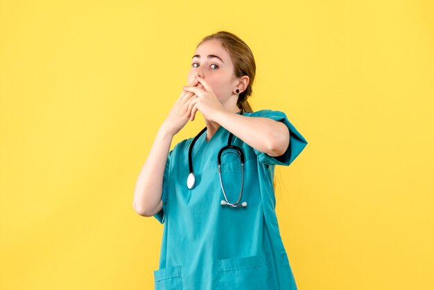 Front view female doctor on yellow background medic hospital emotion health