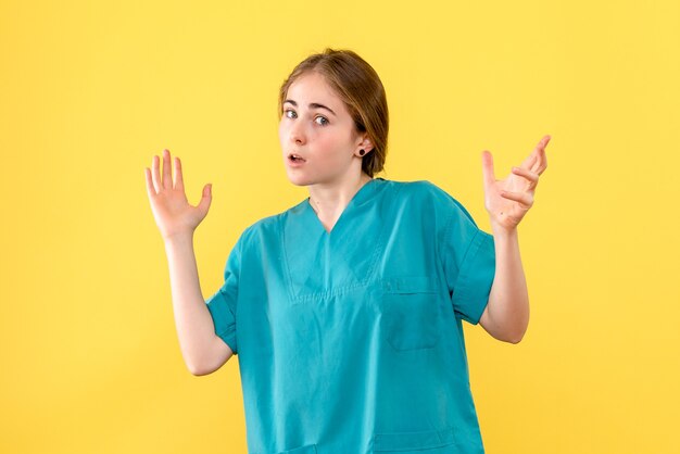 Front view female doctor on yellow background medic hospital health emotion