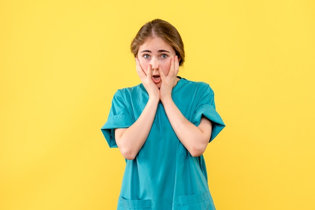 黄色い机の病院の薬の健康感情の正面図の女性医師