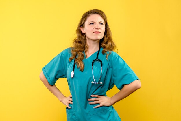 Front view female doctor on a yellow space