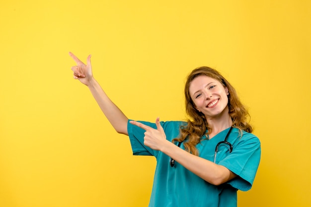 Front view of female doctor on a yellow wall