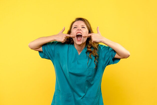 Front view of female doctor on yellow wall