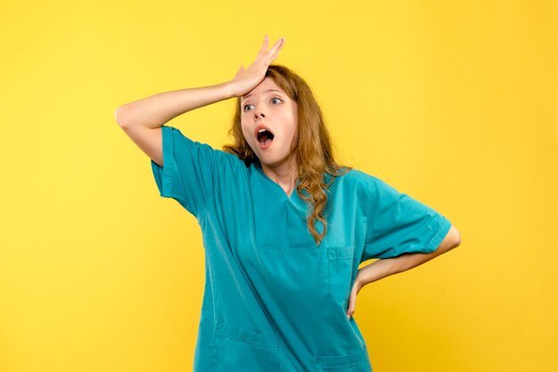 Front view of female doctor on yellow wall