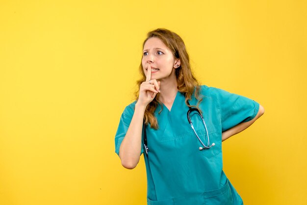 Вид спереди женщины-врача на желтой стене