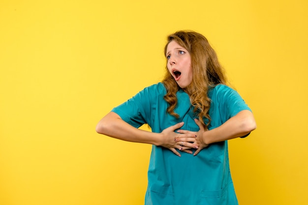 Front view of female doctor on yellow wall