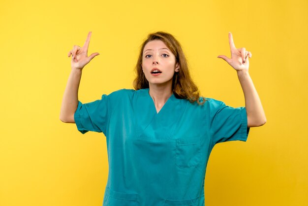 Front view of female doctor on yellow wall