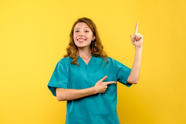 Front view of female doctor on yellow wall