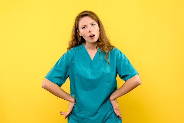 Front view of female doctor on yellow wall