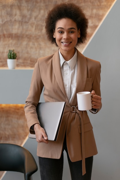 Foto gratuita computer portatile femminile della tenuta dell'economista di vista frontale