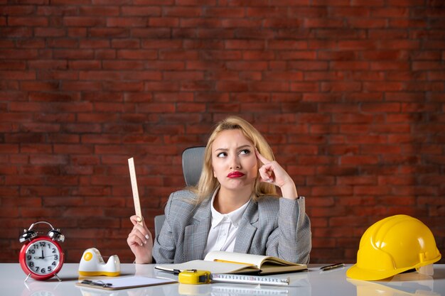 Front view female engineer sitting behind her working place