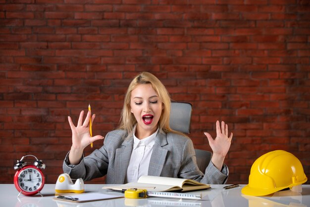 Front view female engineer sitting behind her working place