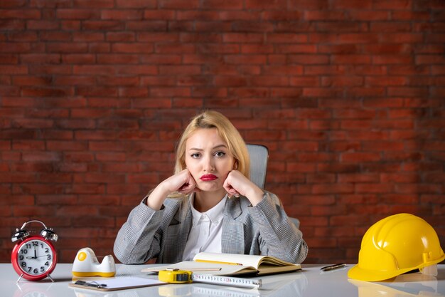 Front view female engineer sitting behind her working place