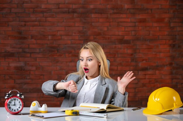 Front view female engineer sitting behind her working place