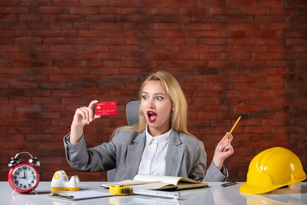 Front view female engineer sitting behind her working place