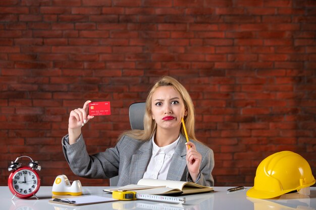 Front view female engineer sitting behind her working place