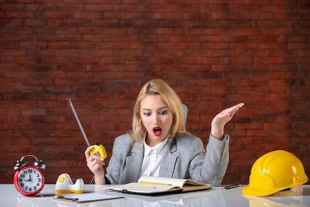 Front view female engineer sitting behind her working place