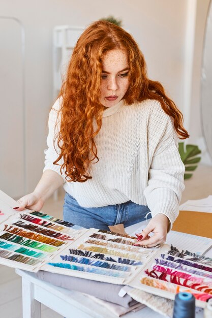 Front view of female fashion designer working in atelier with color palette