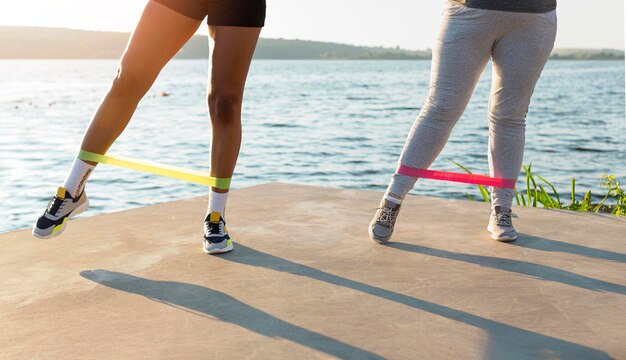 Front view of female friends working out by the lake together