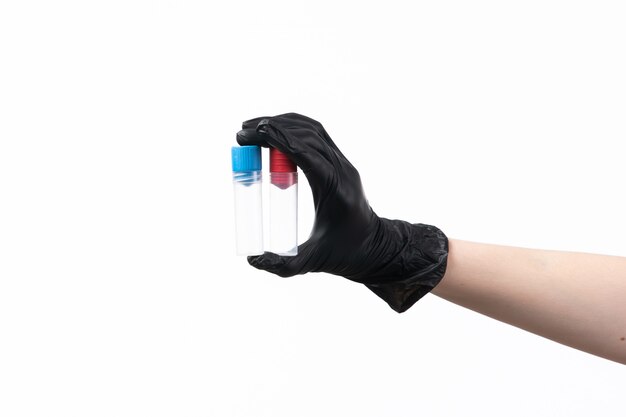 A front view female hand in black glove holding flasks on white