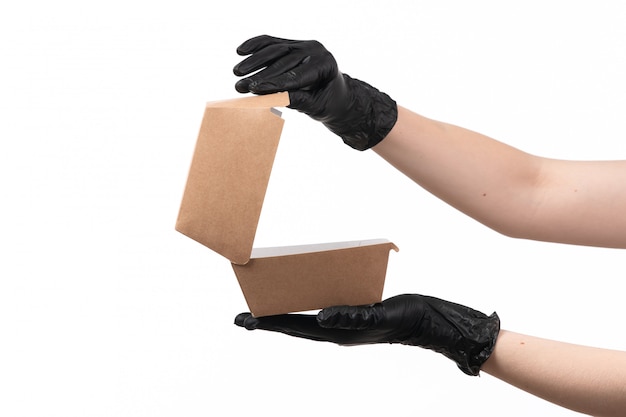 A front view female hand holding an empty food package on white