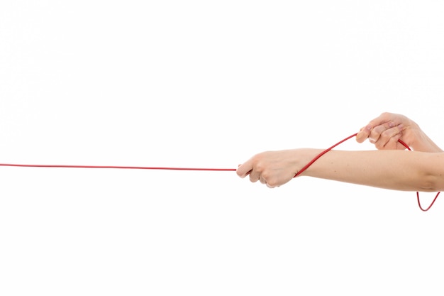 A front view female hand pulling up red rope on the white