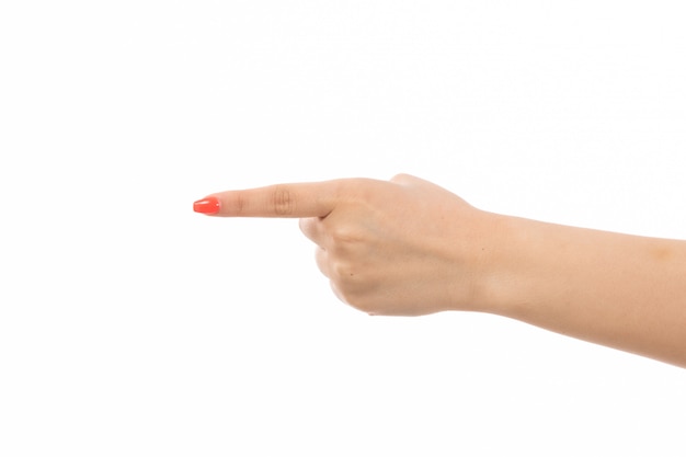 A front view female hand with colored nails pointing out her finger on the white