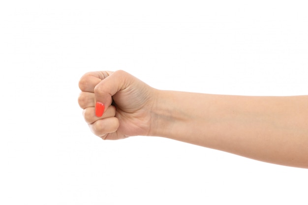 A front view female hand with colored nails tight fist on the white