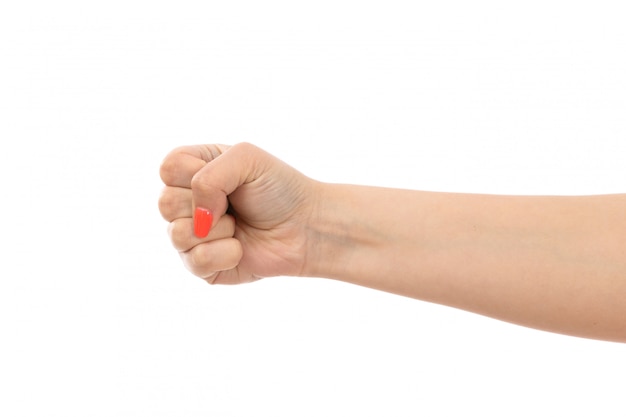 Фронтальный вид женской руки с разноцветными ногтями в кулак на белом