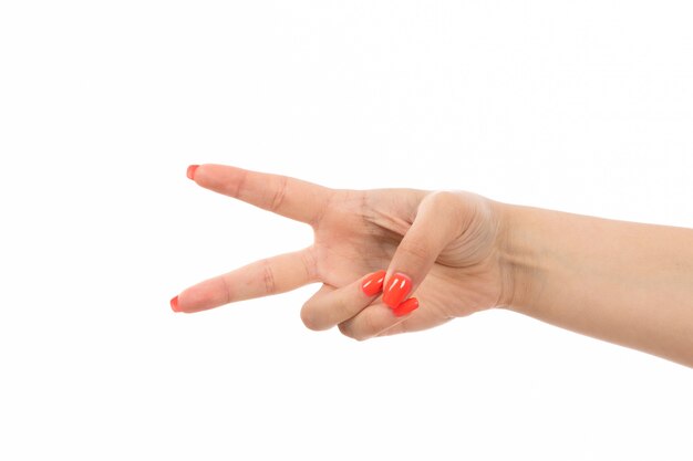 a front view female hand with colored nails victory sign on the white