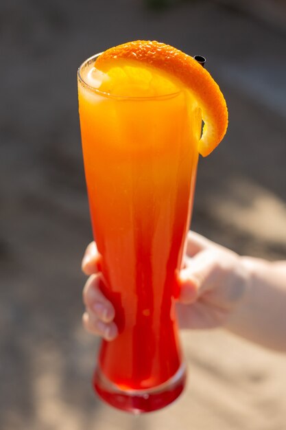 A front view female holding cocktail fresh and iced during daytime cocktail drink juice summer