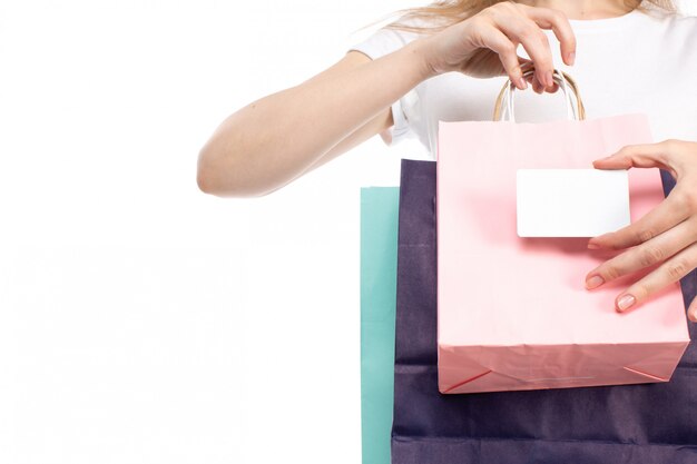 A front view female holding different colored shopping packages and white card on the white