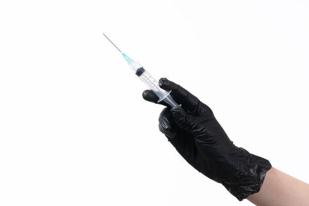 A front view female holding injection in black glove on white