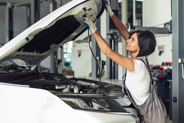 Front view female mechanic fixing car